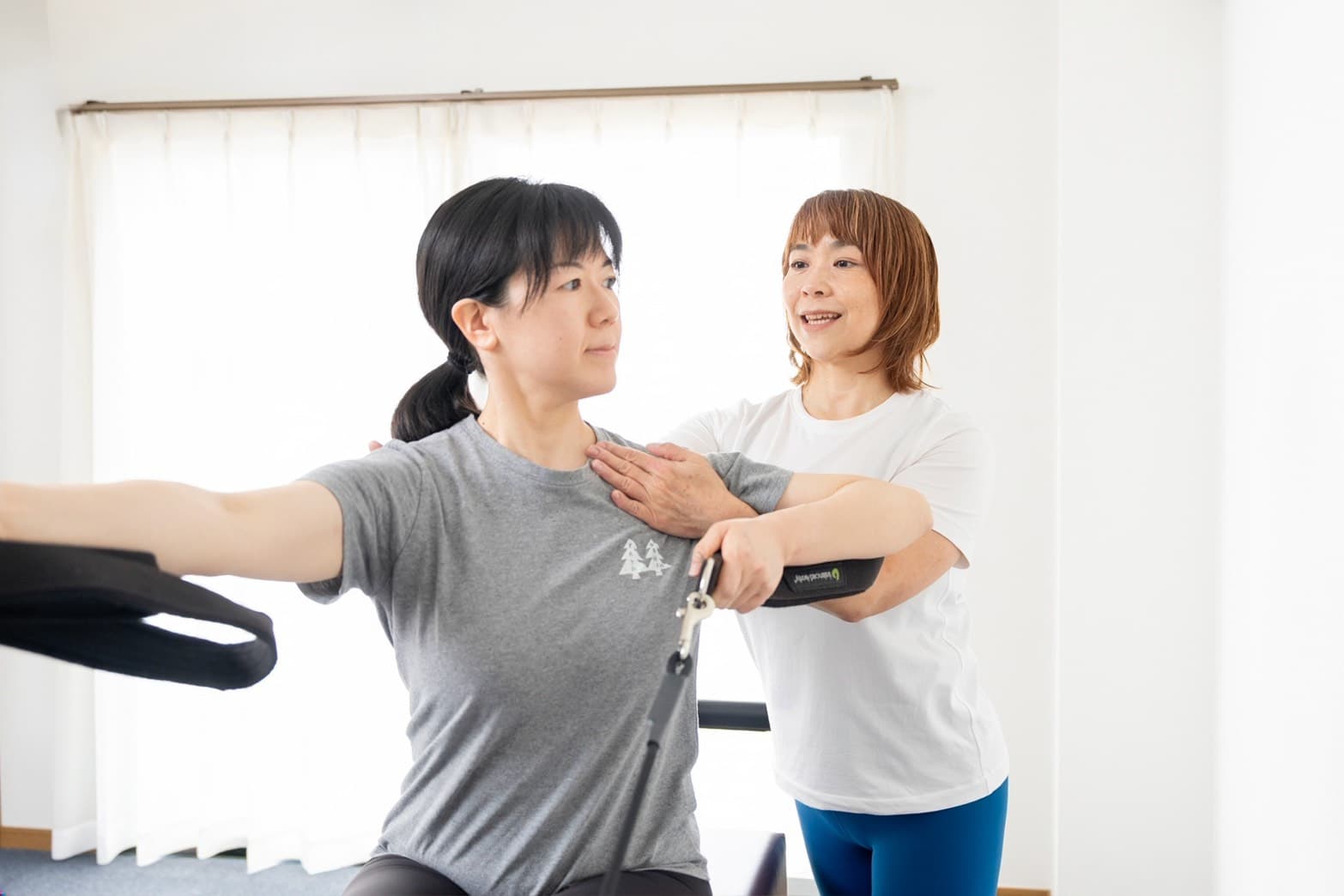 インストラクターが肩まわりの位置を確認しながら動きを伝えている様子